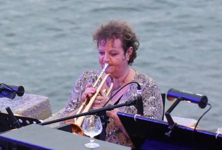 Annette Brown playing the trumpet in Sedos' 2019 production of A Swell Party at the Minack Theatre in Cornwall